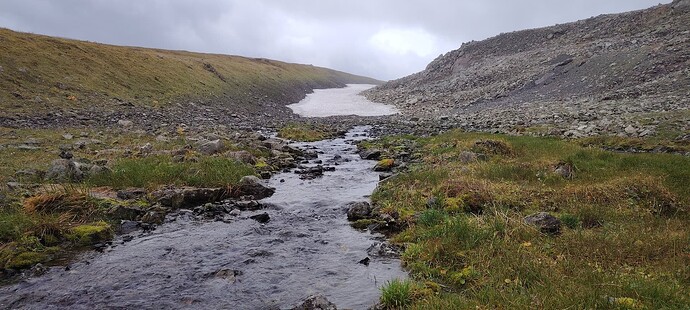 Из под снежника течёт полноводный ручей