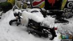  Мотоцикл с волосами и трехколёсный велосипед позади. Занесены снегом.
