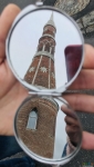 Отражение башни монастыря в карманном зеркальце