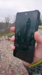 Отражение памятника-якоря в смартфоне